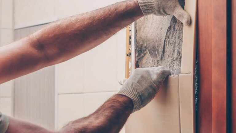 someone removing tile to reveal asbestos